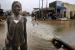 Des enfants jouent dans l'eau qui est evacuee dans une rue asphaltee dans le quartier Guinawrail. Thiaroye, Senegal, 16 septembre 2009.
