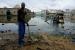 Un homme tente de nettoyer les ordures devant sa maison faisant face a une mosquee cernee par l'inondation dans le quartier Guinawrail a Thiaroye, Senegal, 16 decembre 2009. Les pompiers ont installe une pompe d'evacuation de l'eau.